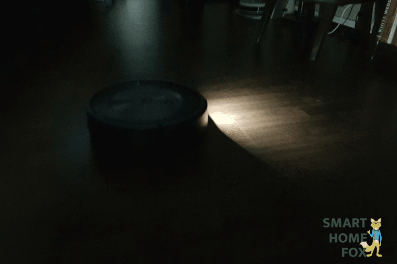 Man sieht den iRobot Roomba j7+ dankt seiner Lampe bei absoluter Dunkelheit die Wohnung reinigen.